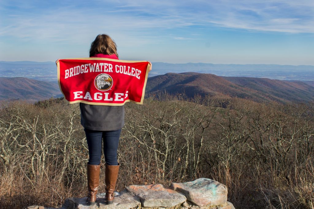 Student at Reddish Knob holding Bridgewater College flag