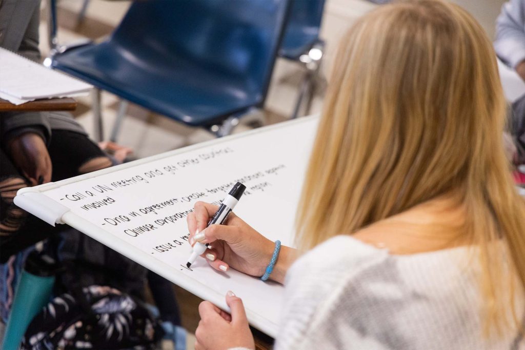 Woman writing on white board