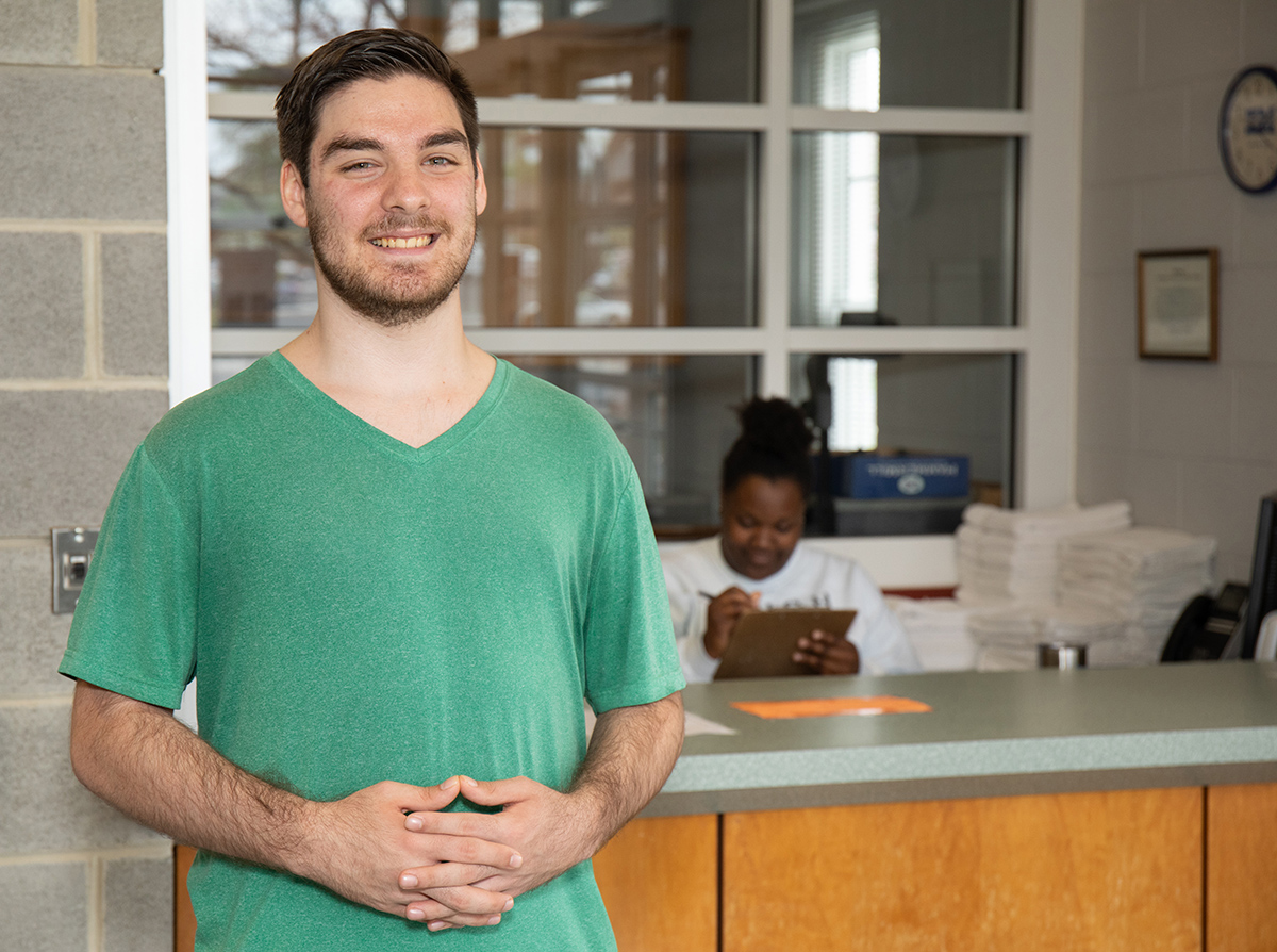 Lane Salisbury standing in front of counter with a green shirt