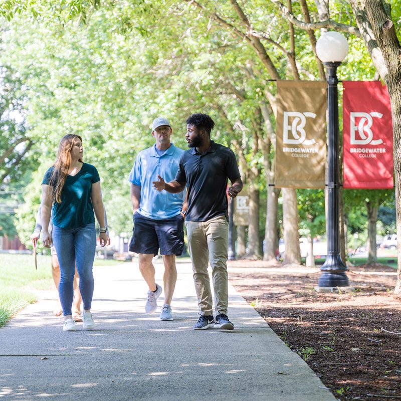 Tour guide leading prospective student and parent on tour outside