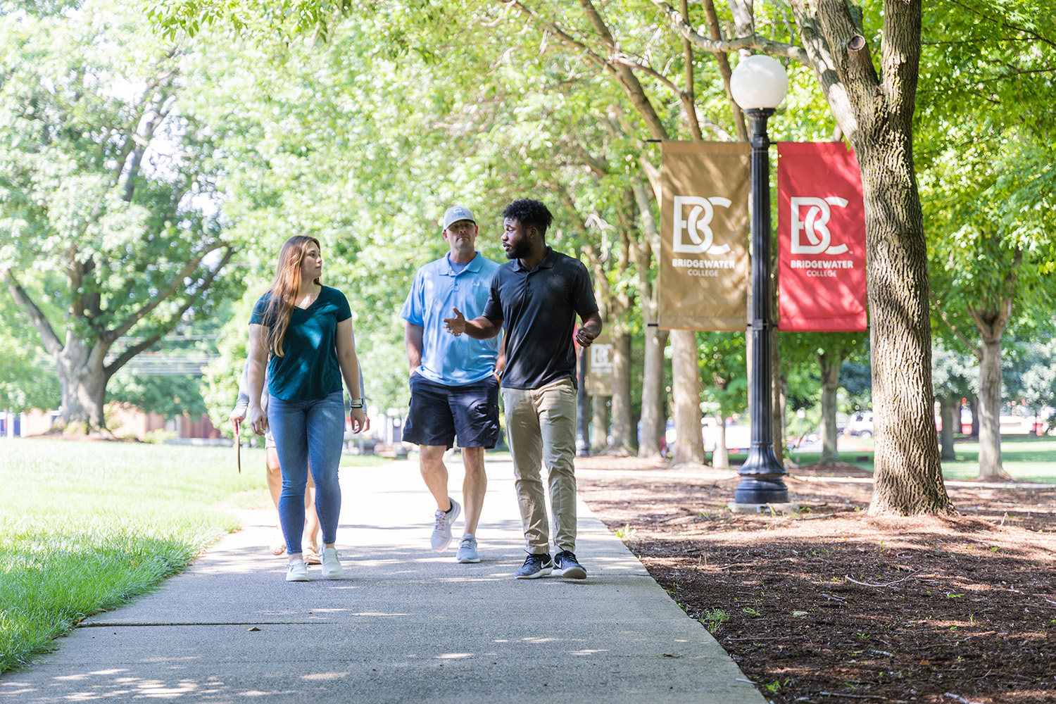 Tour guide leading prospective student and parent on tour outside