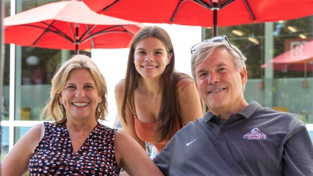 Mother, daughter, and father pose for a picture