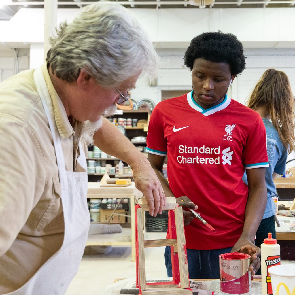 Professor helping student with art project