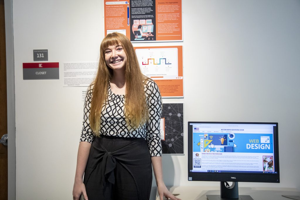 Student standing in front of web design project 