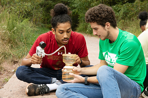 Two students using equipment for an environmental science project