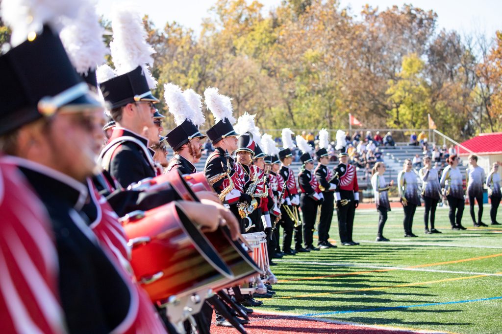 Members of the Marching Band standing in a line on the football field during a performance
