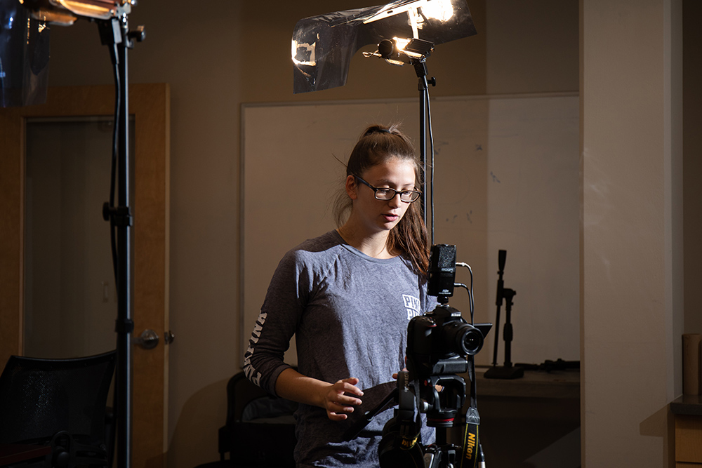 Student working in a studio with camera equipment