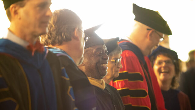 Line of professors smiling at commencement