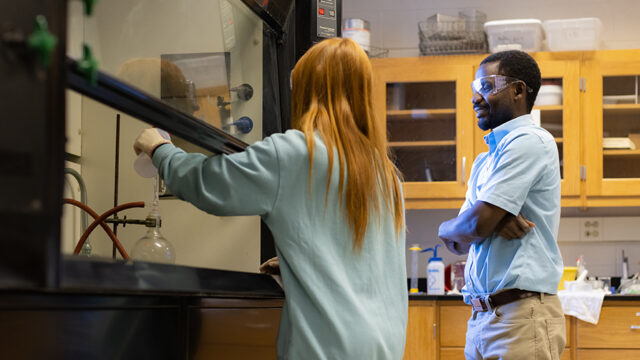 Chemistry student with professor in chemistry lab