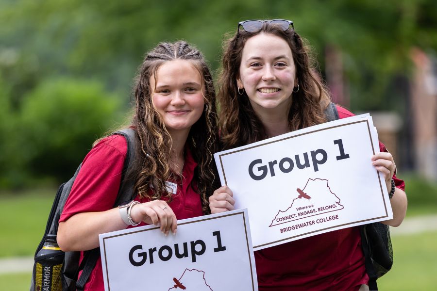 Two Student Soar Mentors holding group one signs and smiling, together