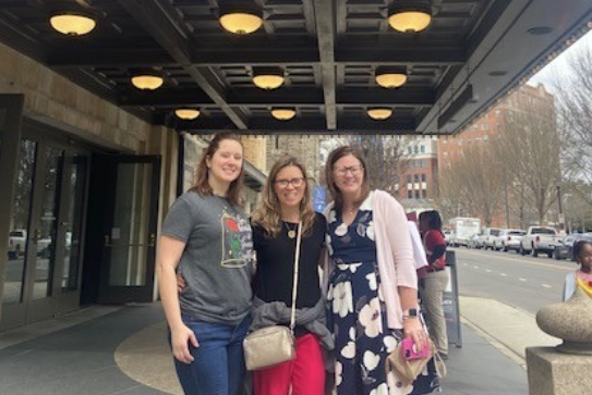 Three alumni stand in front of the Altria Theater